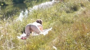 A casual passerby young guy saw a naked Milf sunbathing on river bank. Peeping. Spy camera. Naked in public. Nude beach. Wild be